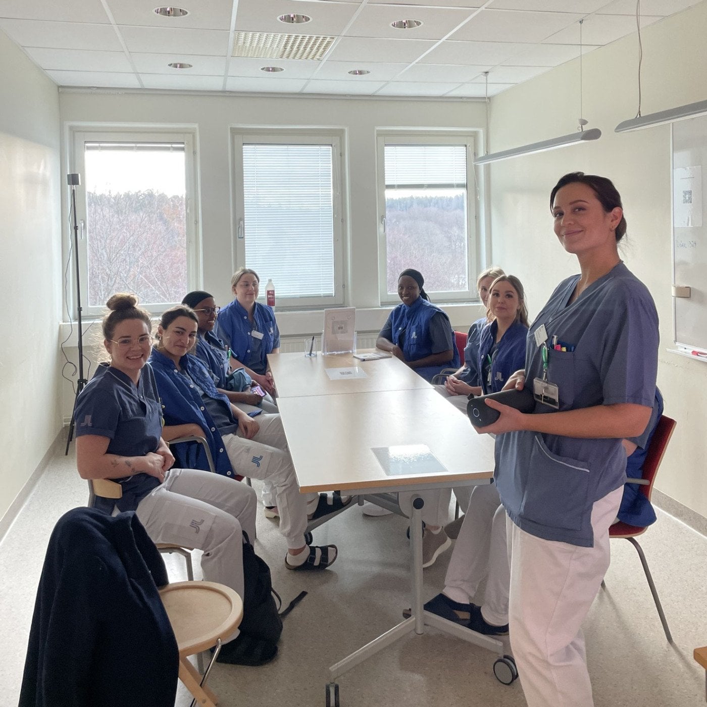 En grupp sjuksköterskor som sitter runt ett konferensbord.