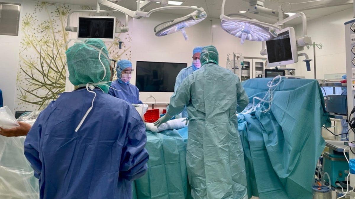 En grupp läkare i operationskläder opererar på ett sjukhus.