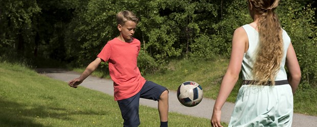 Två barn som spelar fotboll